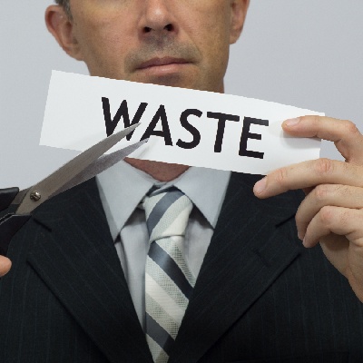 Man holding scissors with WASTE written on piece of paper