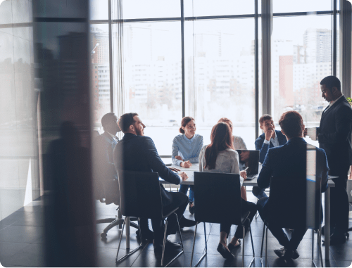 Office room full of corporate employees in suits having a meeting